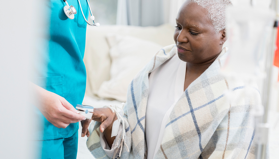 African American woman having her blood oxygen measured with a pulse oximeter